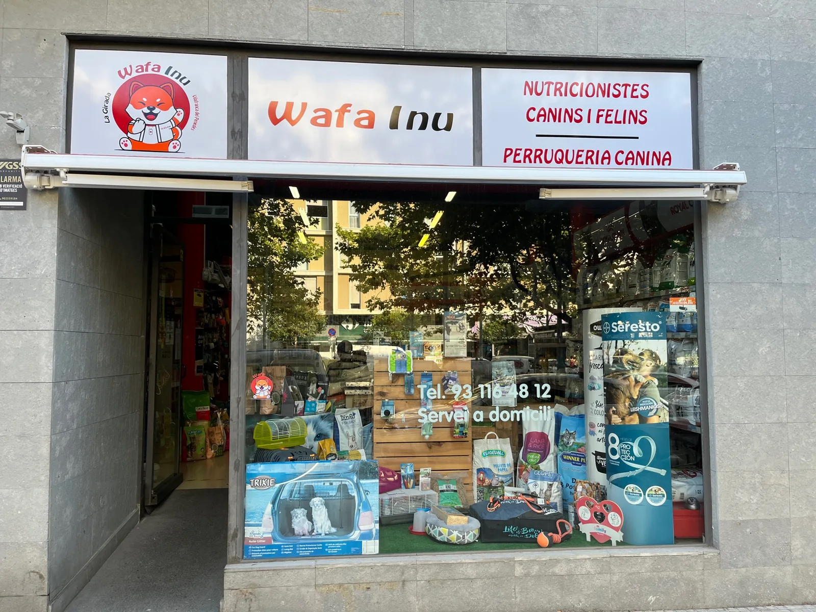 Façana de WAFA INU a la Rambla de la Girada amb el rètol: Wafa Inu, nutricionistes canins i felins, perruqueria canina.